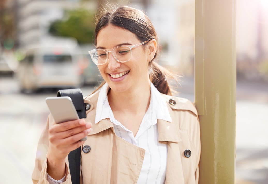 Smiling woman wearing glasses checking timesheet notification using her phone