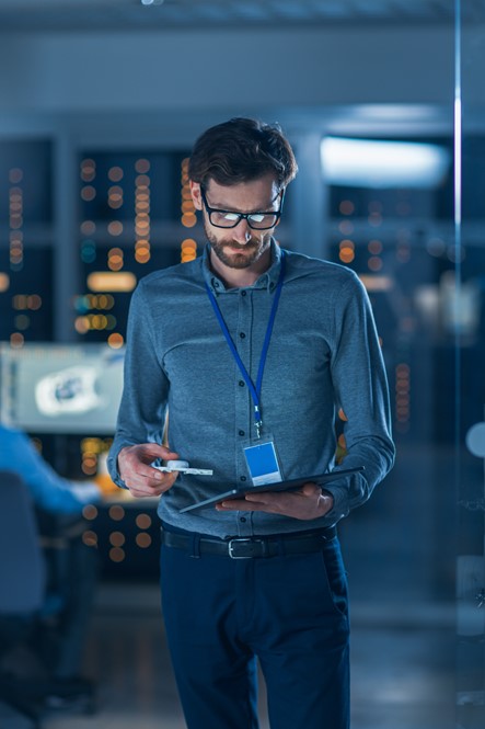 Productive man using a tablet to check time entries and reporting