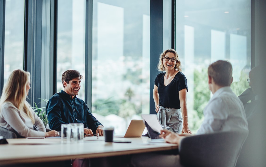 Satisfied project administrators and managers discussing about project status in an office