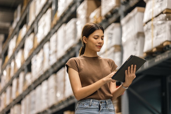 Woman working in a factory tracking hours with ease using a tablet