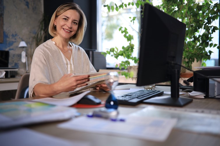 Happy woman working with ease in front of her computer at home