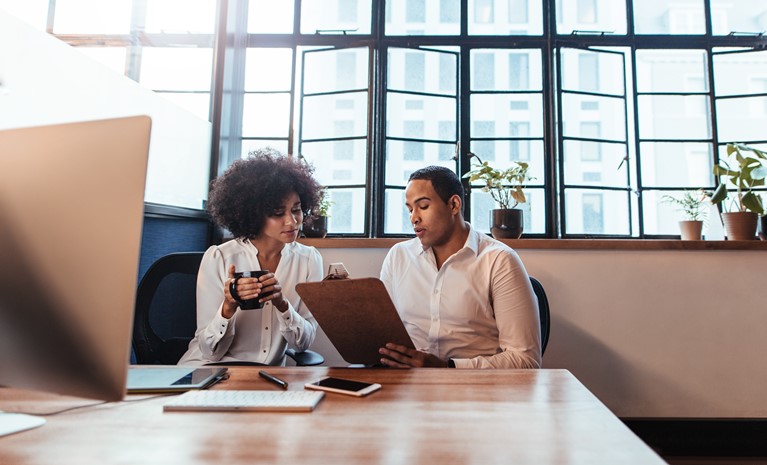 Two entrepreneurs discussing the timesheet reporting and analytics