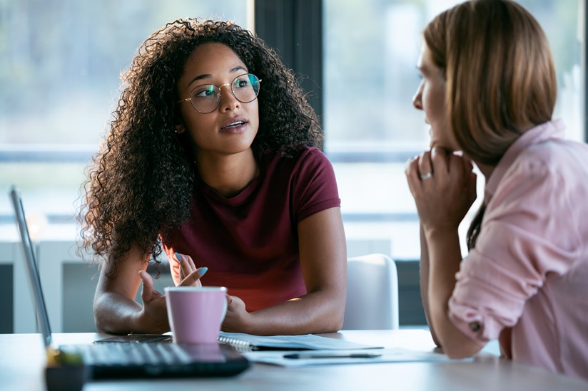 Two women discussing work status for transparency