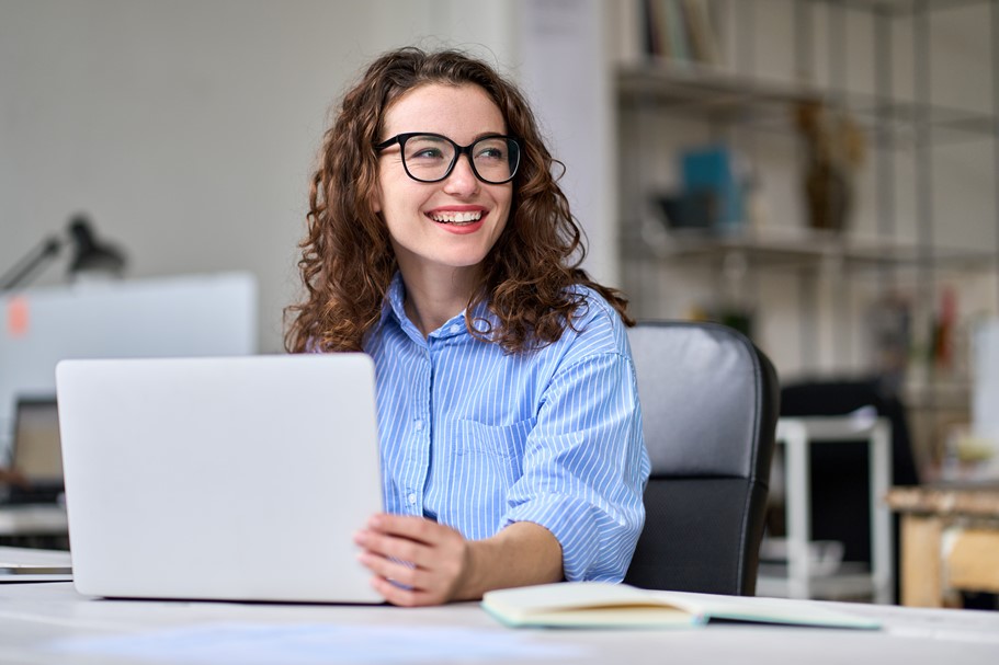 Payroll administrator happily doing her job using a laptop with accurate and realtime timetracking data