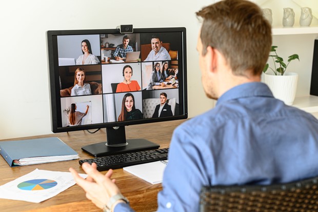 Hybrid workforce collaborating virtually while discussing progress of their project