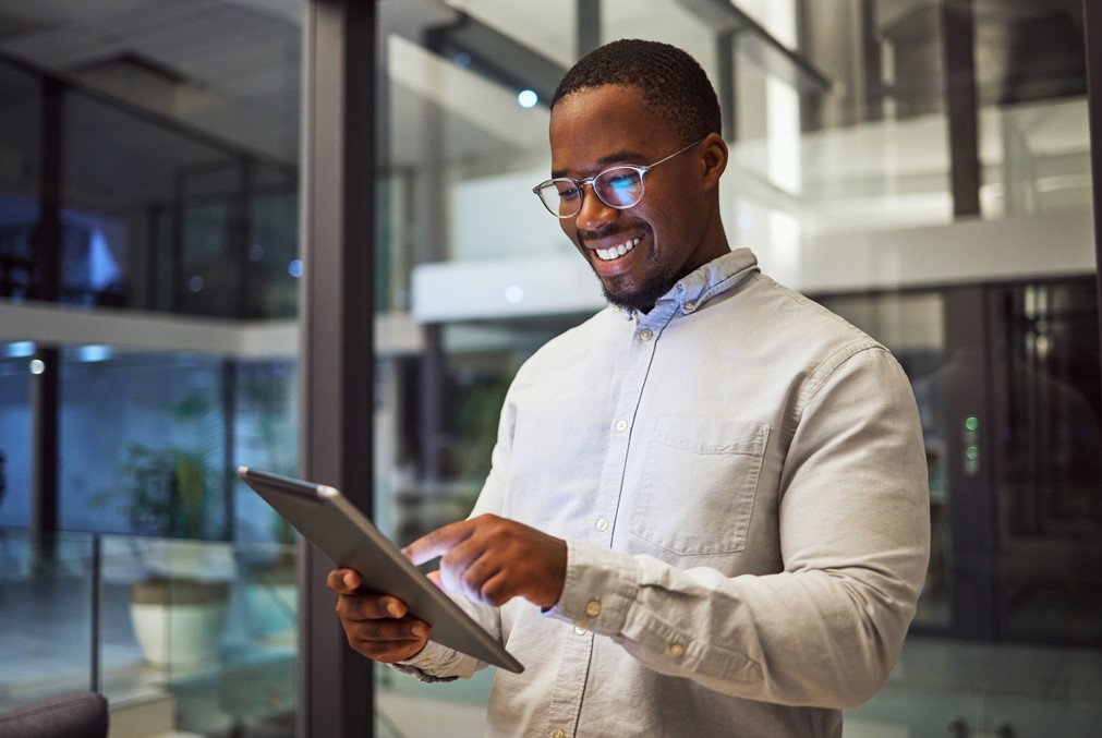 Happy worker checking the notifications received from OfficeSeries using a tablet